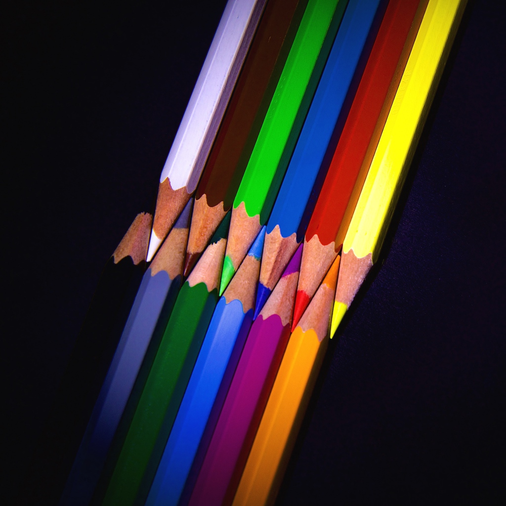 Разноцветные острые карандаши на черном фоне