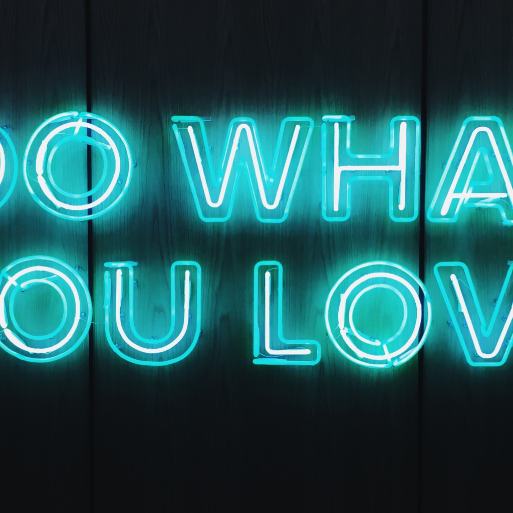 Неоновая надпись Do What You Love на деревянном фоне