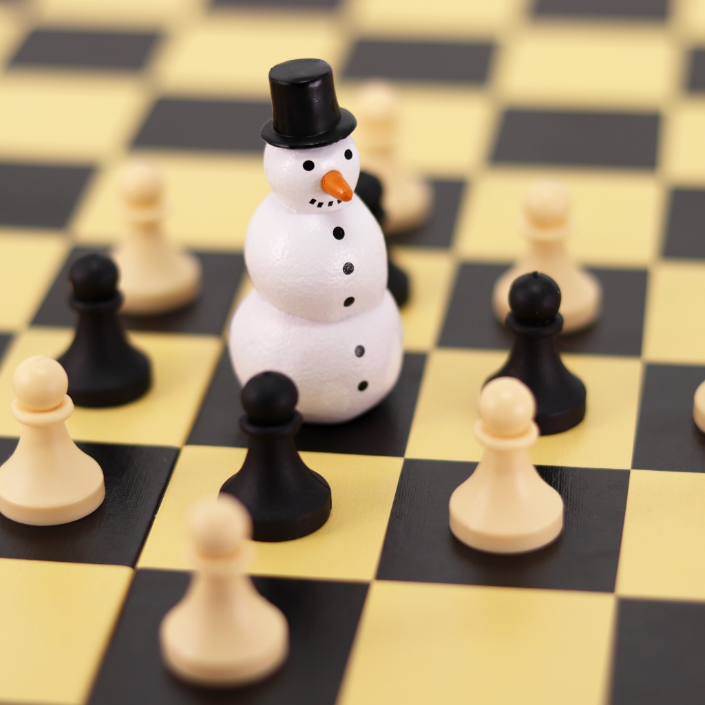 Фигурка снеговика на шахматной доске