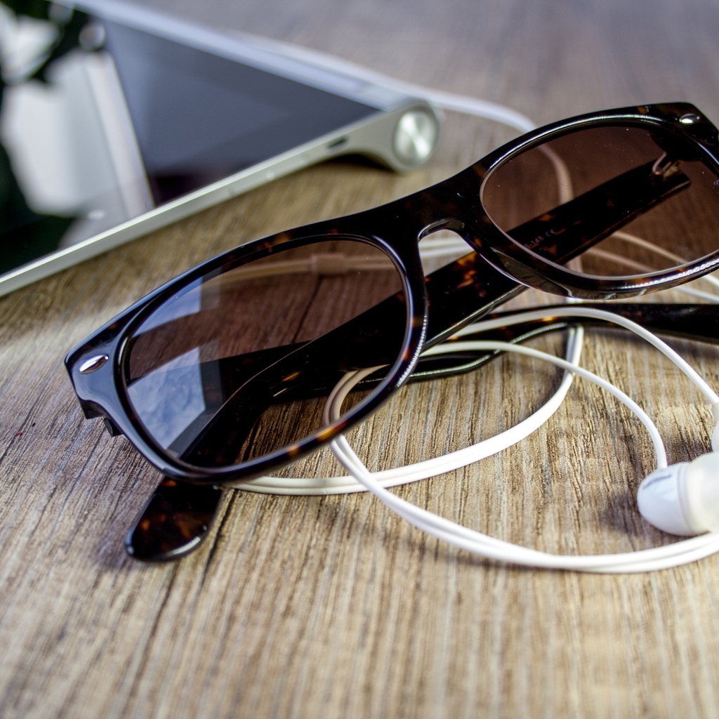 Солнечные очки с наушниками на столе