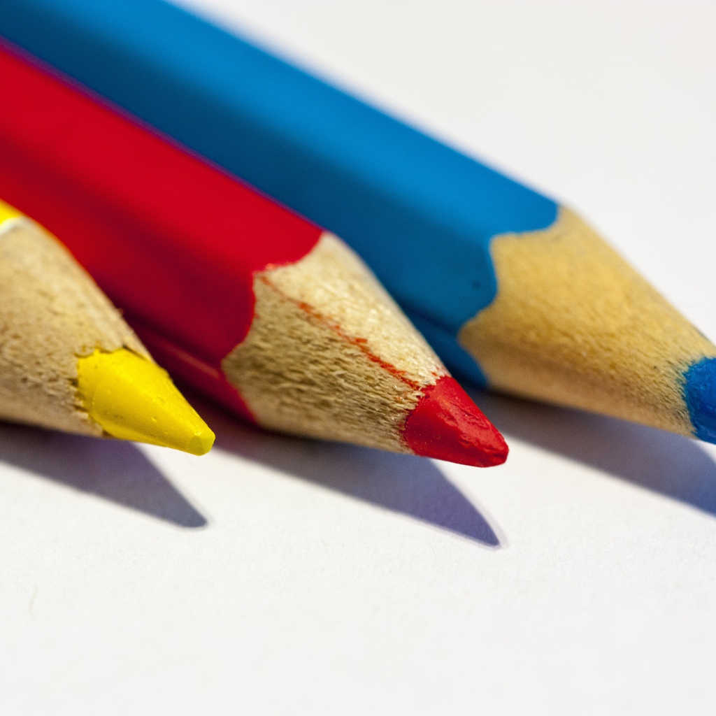 Три разноцветных карандаша на белом фоне
