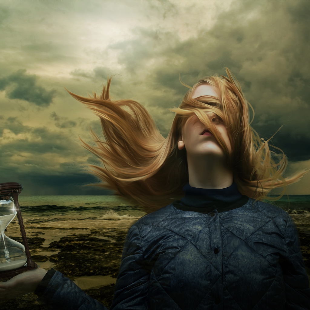 Девушка с волосами на лице держит песочные часы