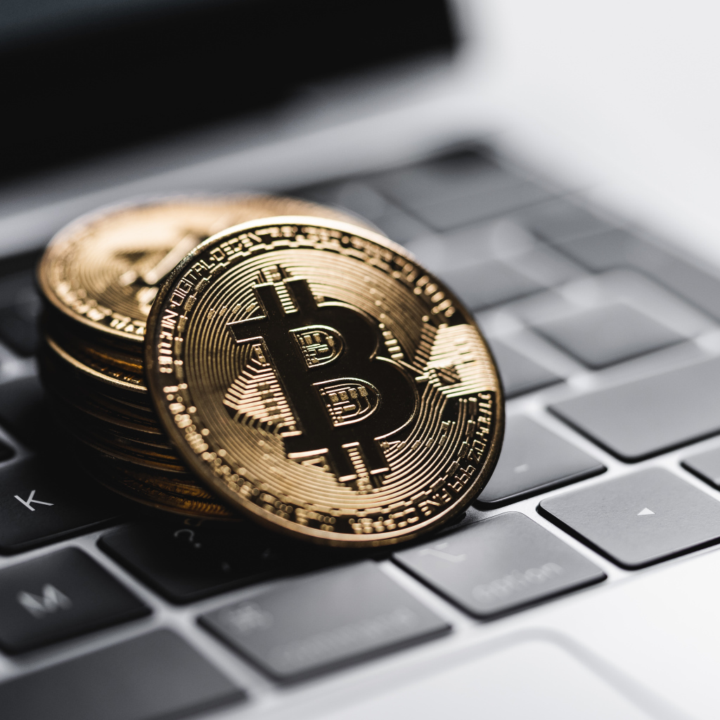 Монеты биткоин лежат на клавиатуре ноутбука 