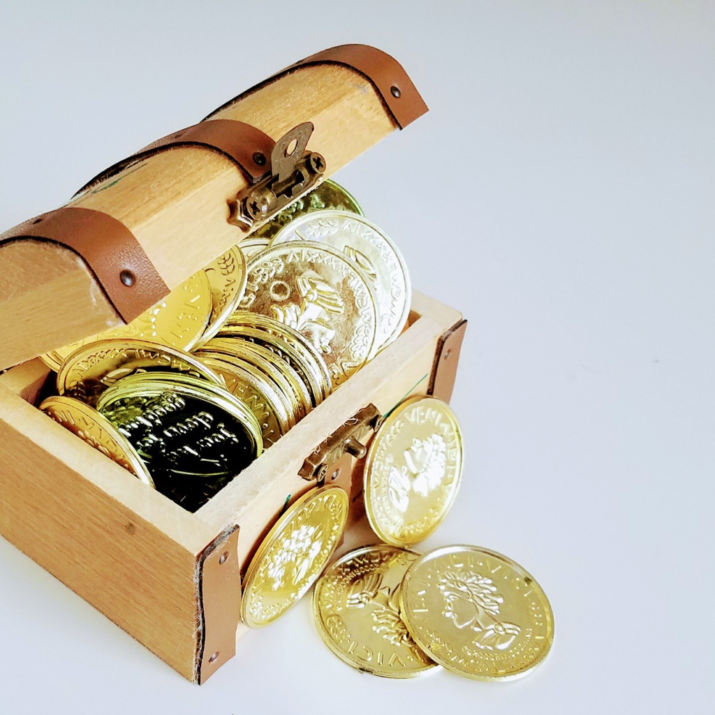 Золотые монеты в сундуке на сером фоне