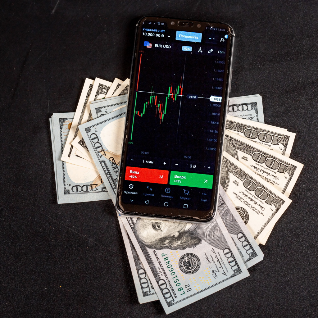 Доллары и смартфон на сером столе 