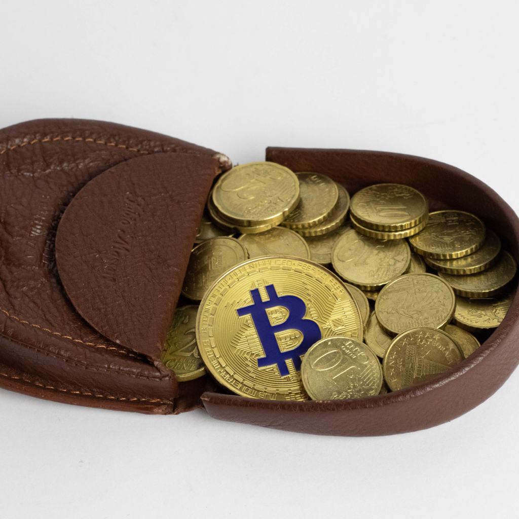 Кожаный кошелек с монетами на сером фоне