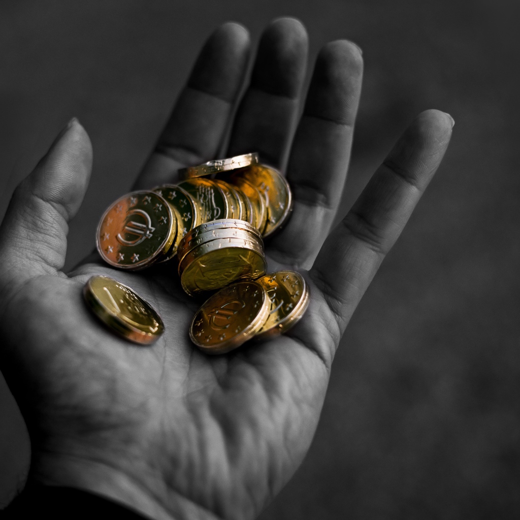 Много монет в руке у мужчины