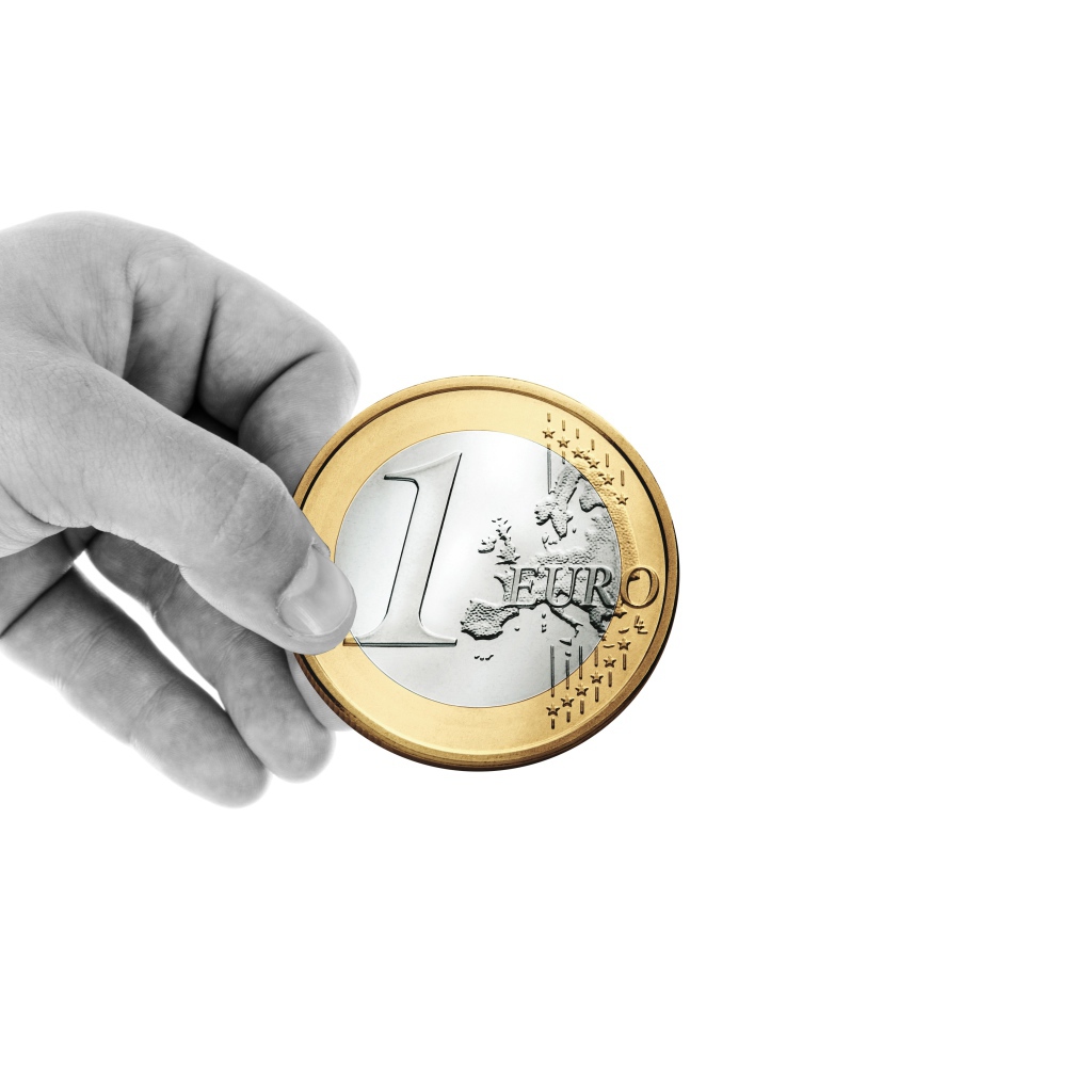 One euro coin in hand on a white background