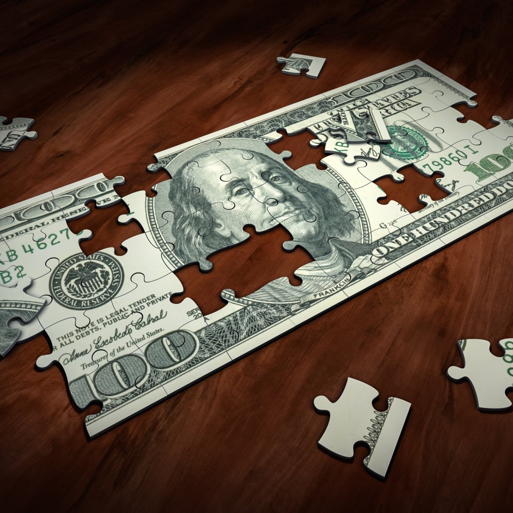 Пазл из купюры сто долларов на столе 