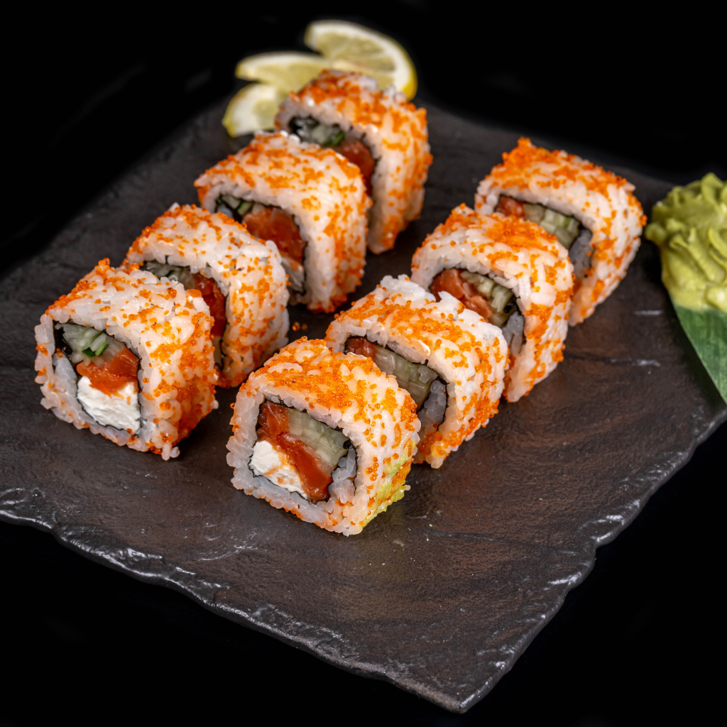 Аппетитные японские роллы с соусом васаби на черном фоне