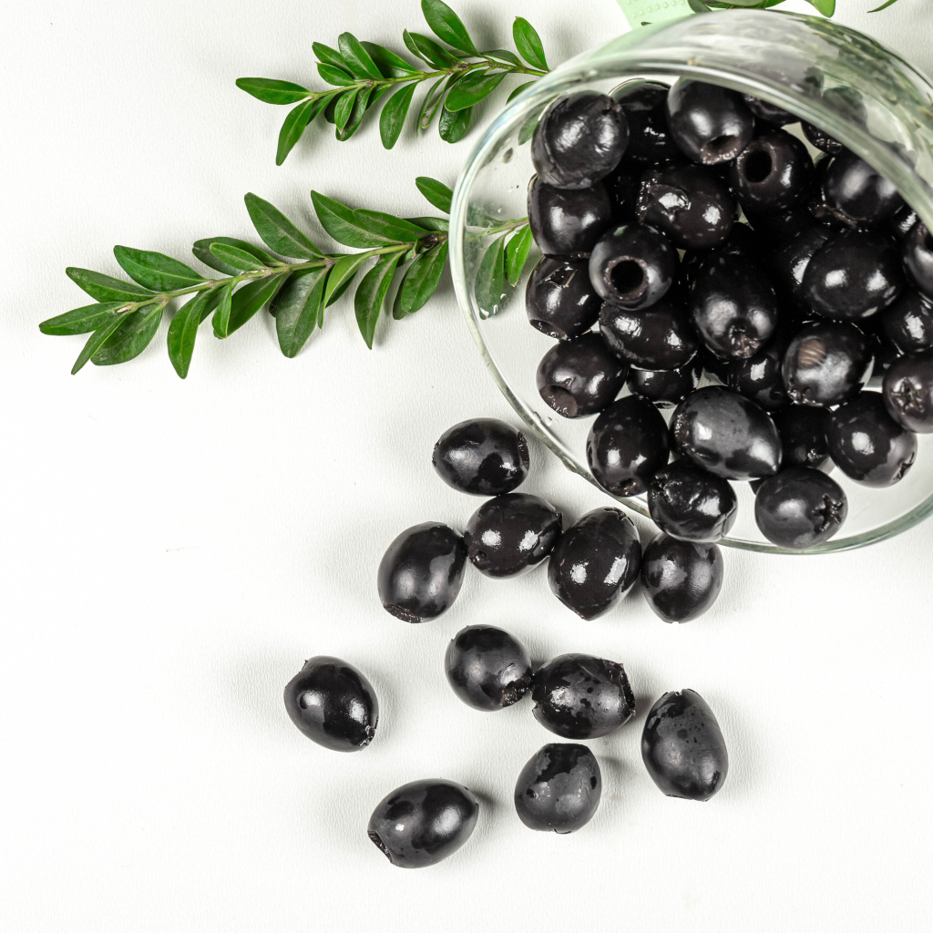 Черные маслины с розмарином на белом фоне
