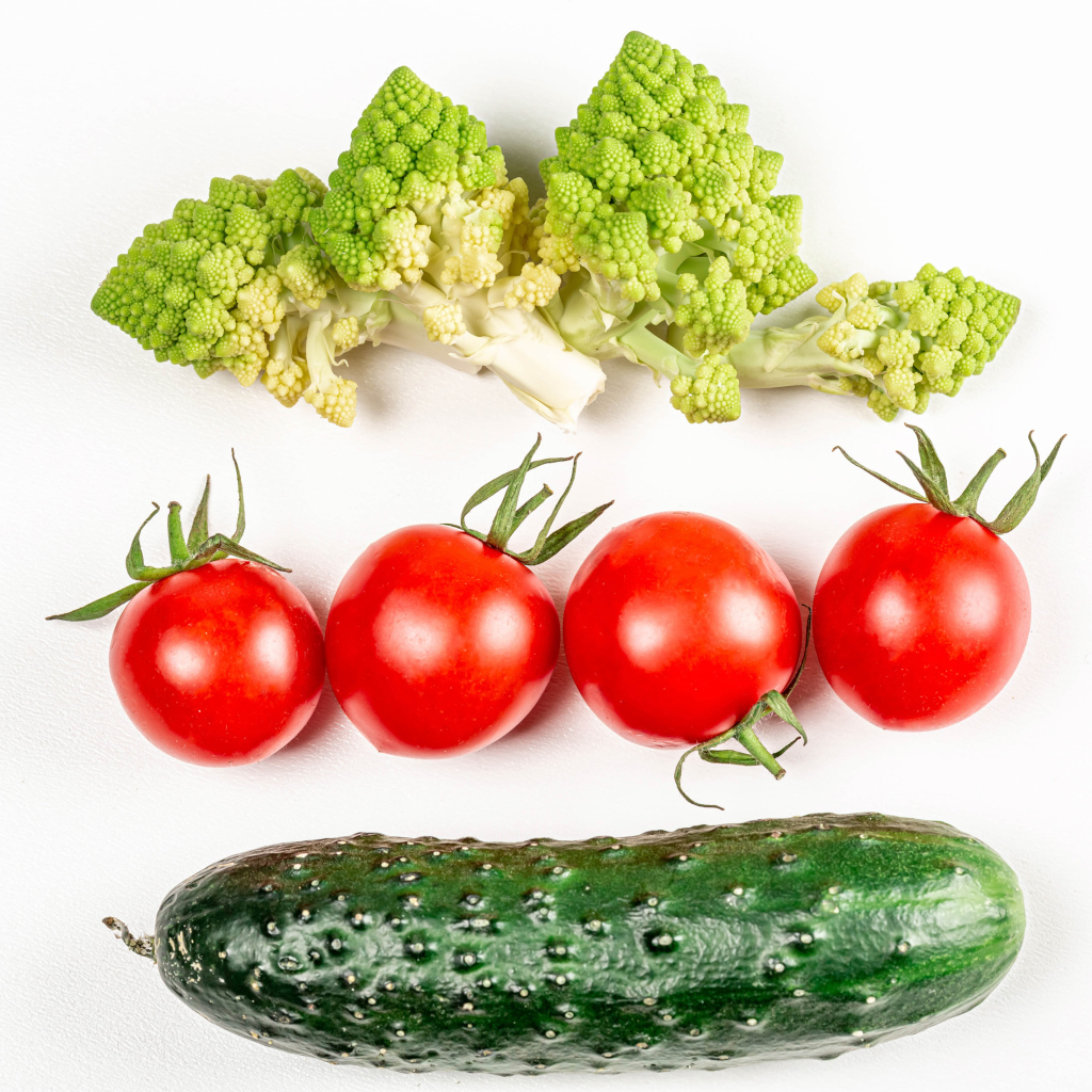 Капуста, помидоры и огурец на белом фоне