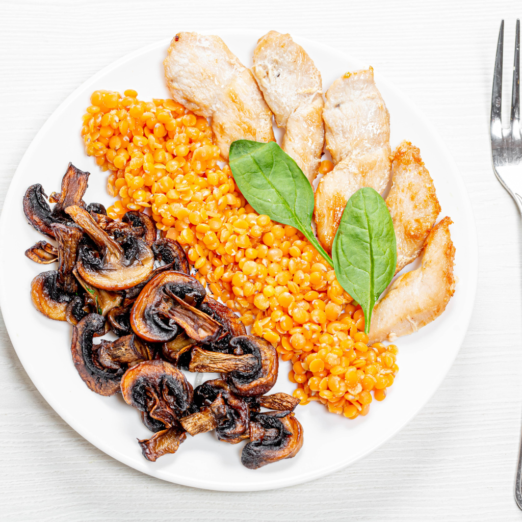 Шампиньоны на тарелке с чечевицей и курицей