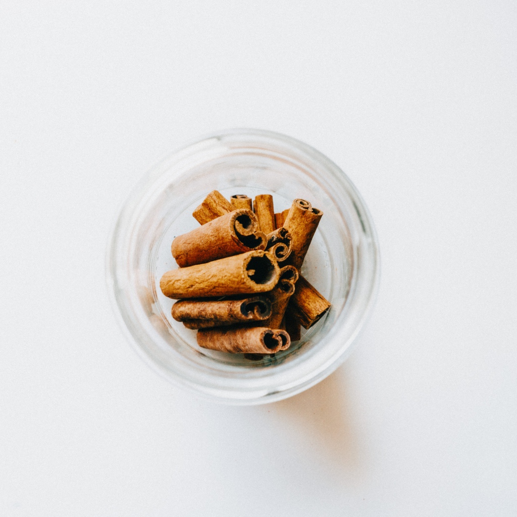 Корица в стеклянной банке на белом фоне 