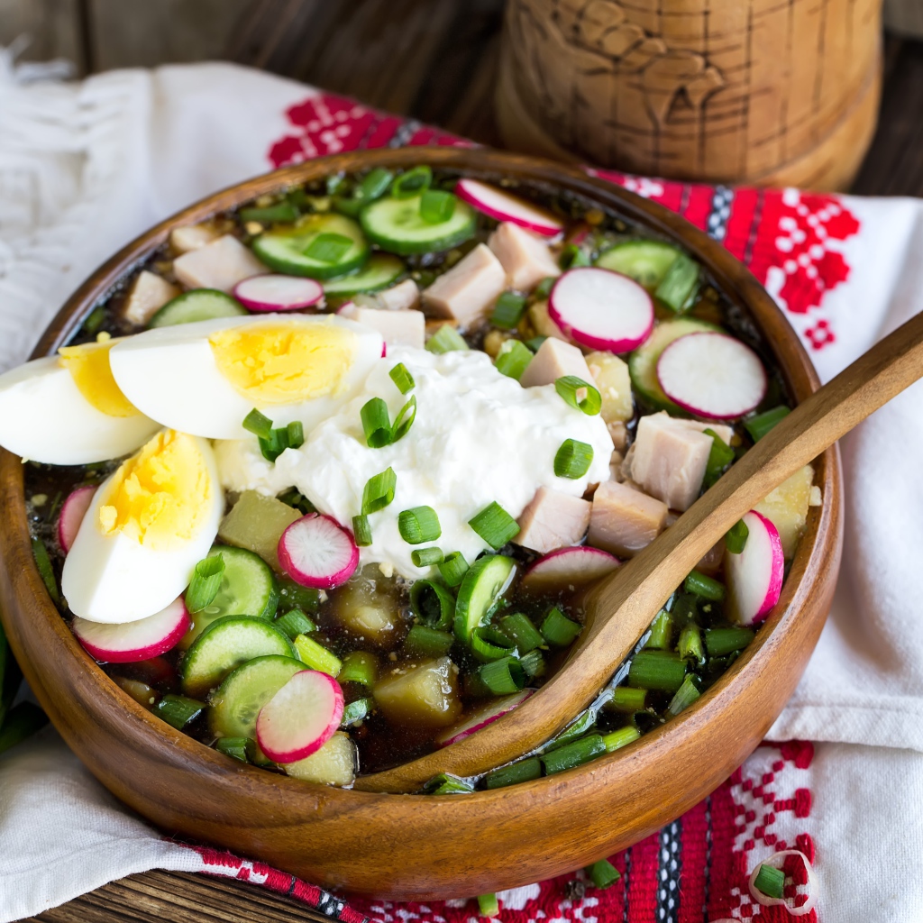 Холодная окрошка в деревянной миске на столе 