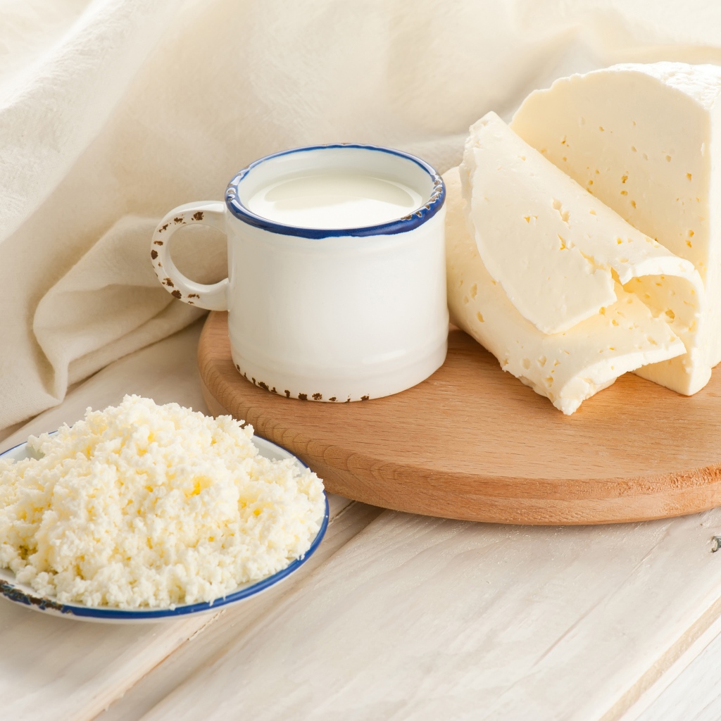 Творог, сыр и кружка молока на столе 