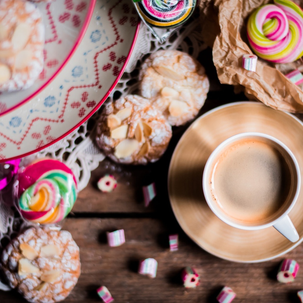 Чашка кофе на столе с печеньем и конфетами