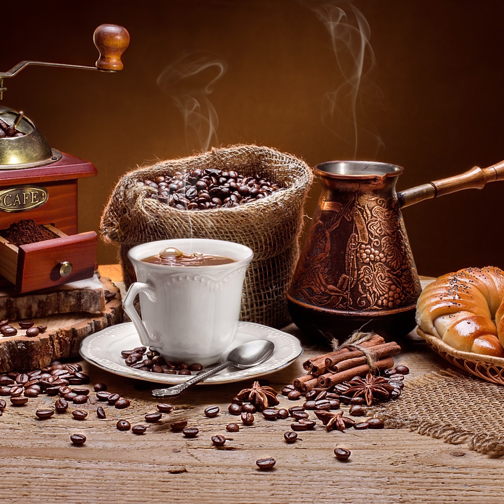 Чашка кофе на столе с круассанами и кофемолкой