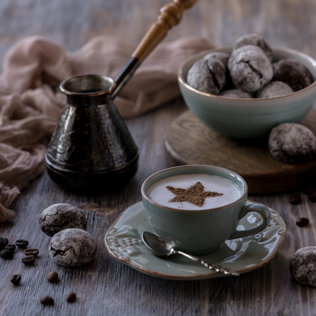 Чашка кофе на столе с пряниками и зернами