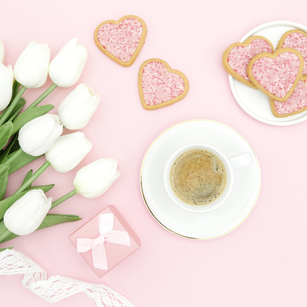 Чашка кофе с печеньем на столе с букетом белых тюльпанов
