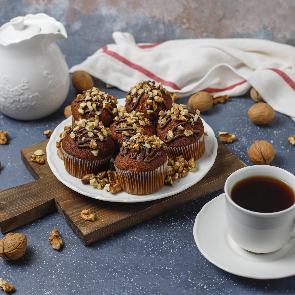 Вкусные шоколадные кексы с орехами на столе с кофе
