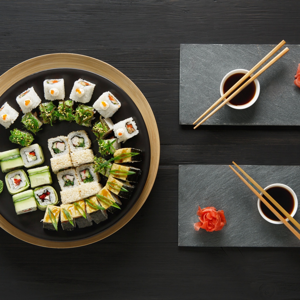 Вкусные  роллы на столе с соевым соусом и палочками 