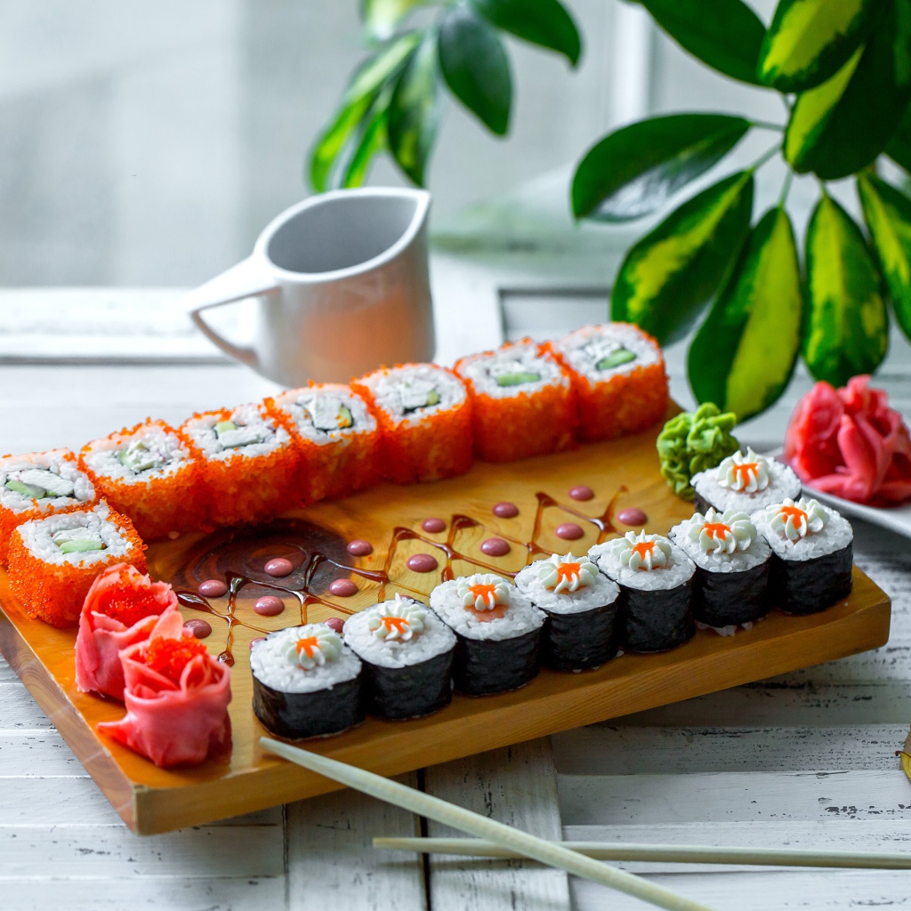 Вкусные суши и роллы на столе с имбирем