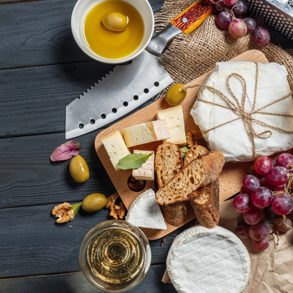 Виноград на столе с сыром, хлебом и оливками