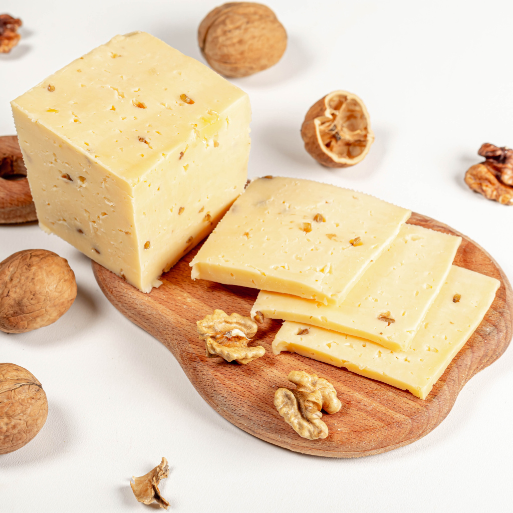 Твердый сыр на доске с грецкими орехами 