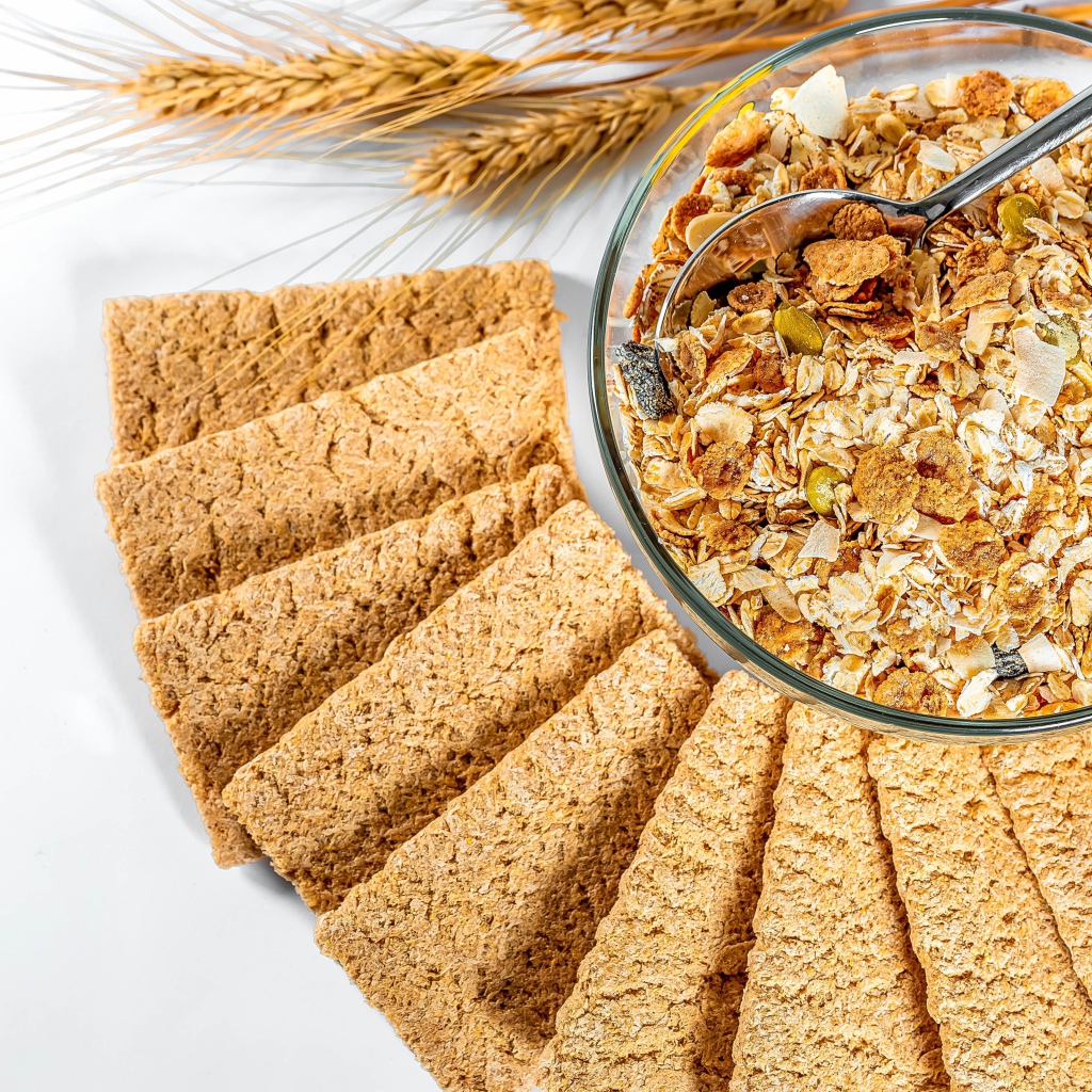 Мюсли в тарелке на столе с хлебцами 