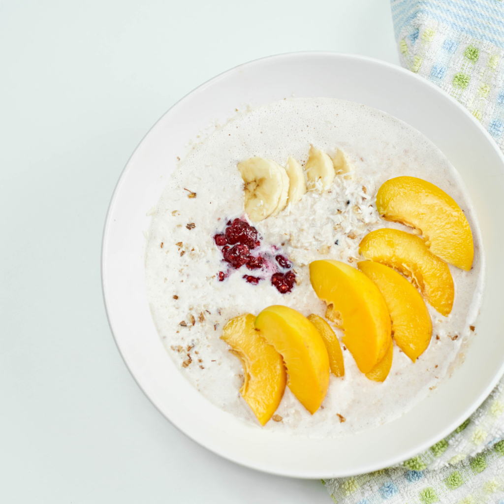 Мюсли с йогуртом в тарелке с кусочками банана и персика