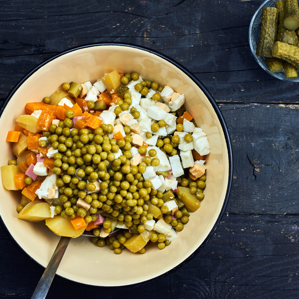 Салат оливье в миске на столе 