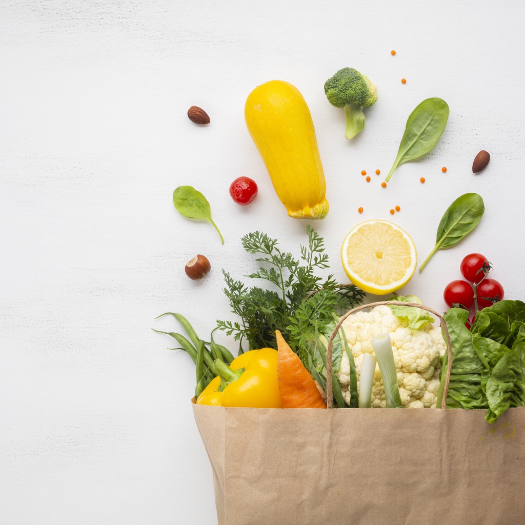 Пакет со свежими овощами и зеленью на сером фоне 