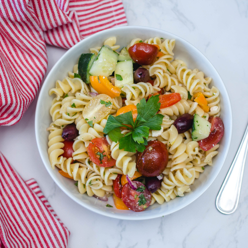 Макароны в тарелке с овощами на столе 