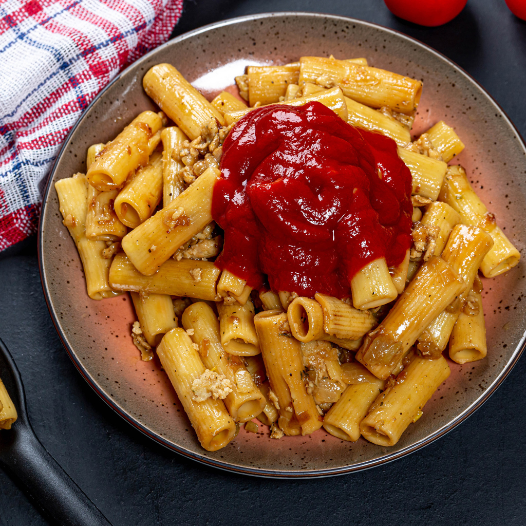 Макароны с мясом и кетчупом на столе