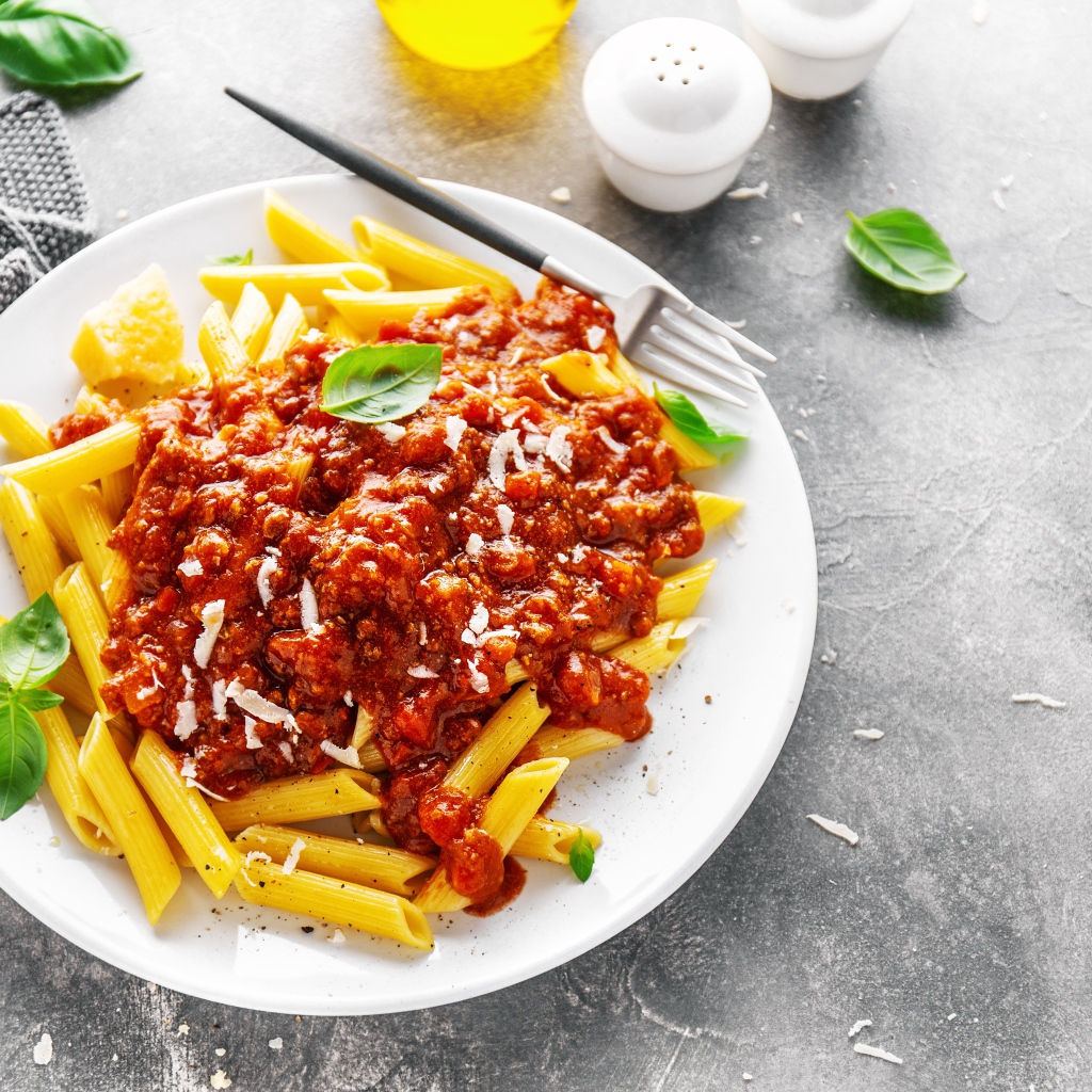 Макароны с соусом на белой тарелке