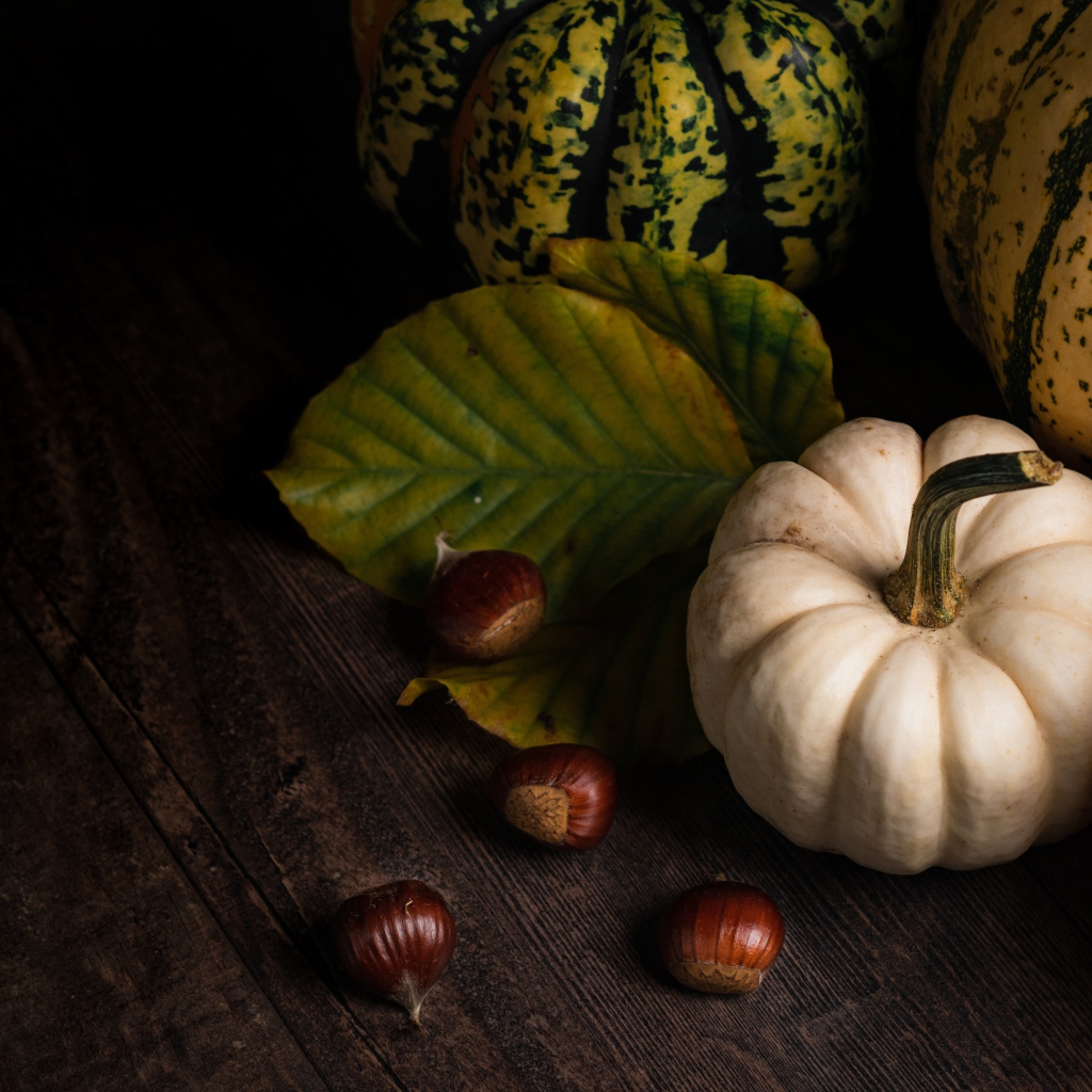 Тыква с каштанами на деревянном столе 