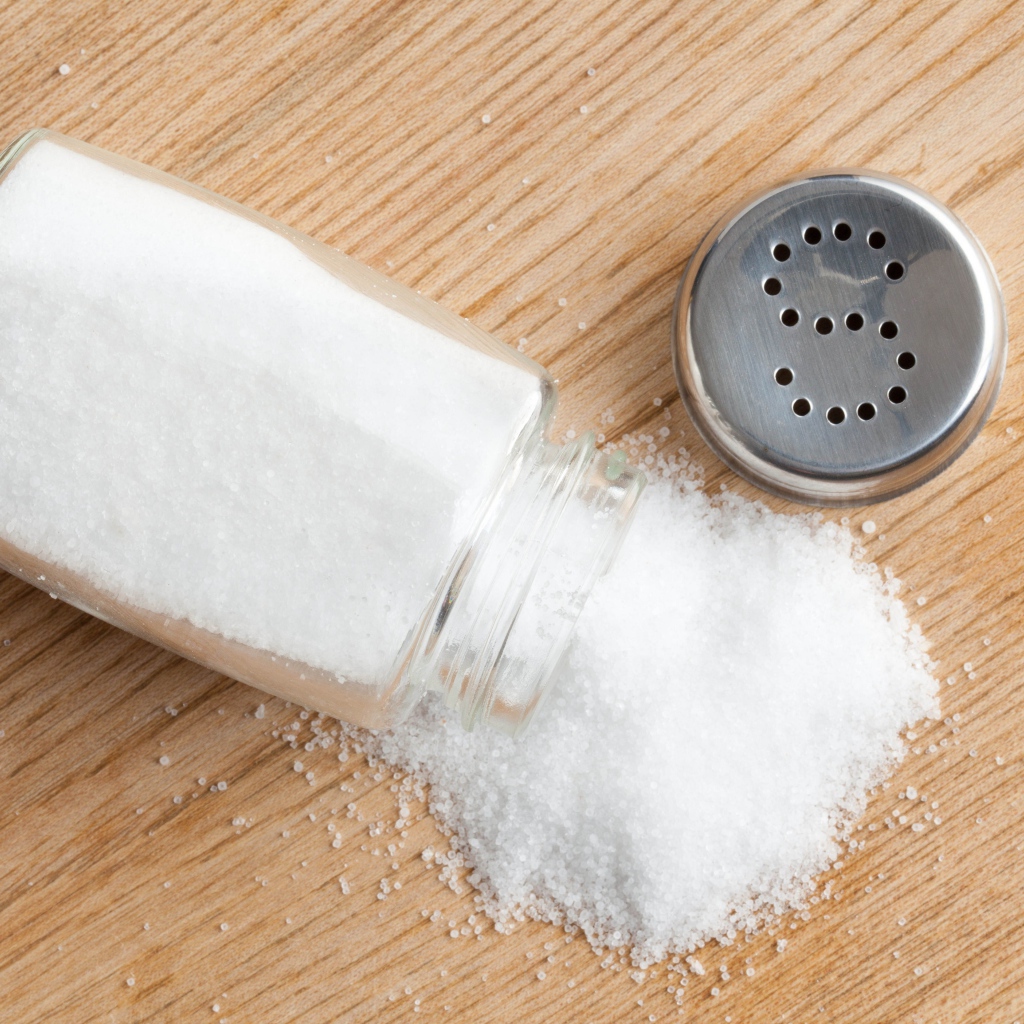 Соль рассыпана на деревянном столе 