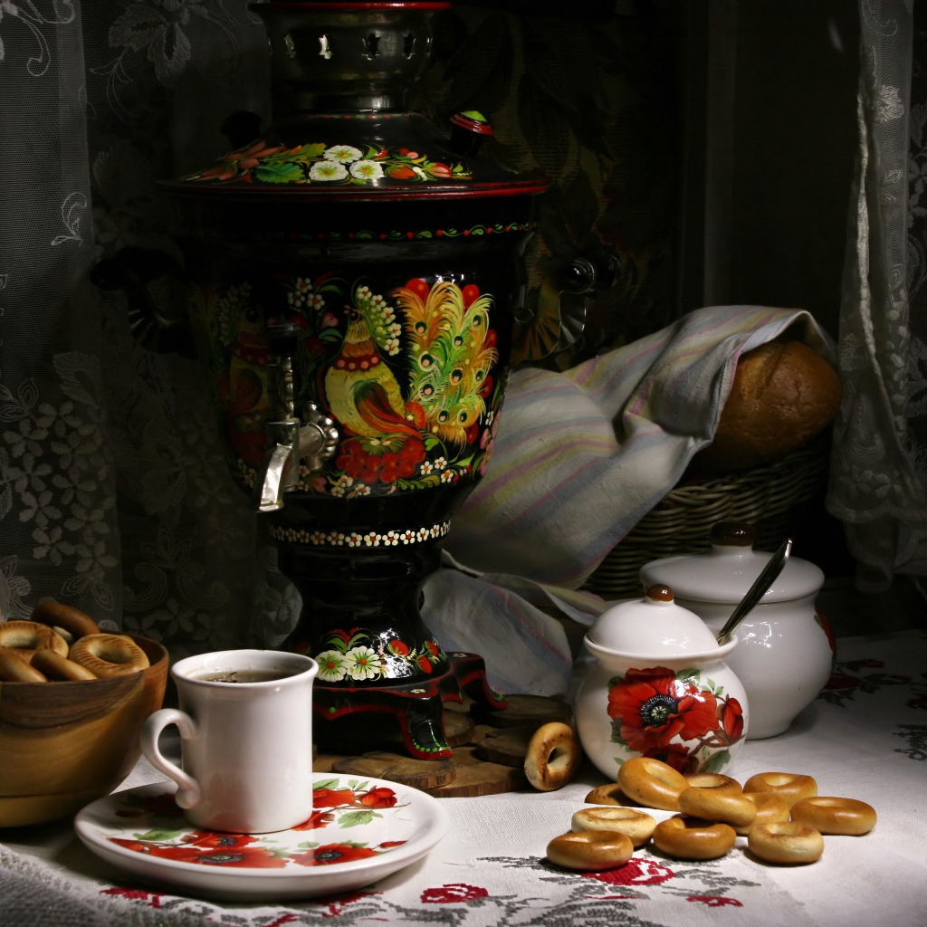 Самовар стоит на столе с чаем и баранками