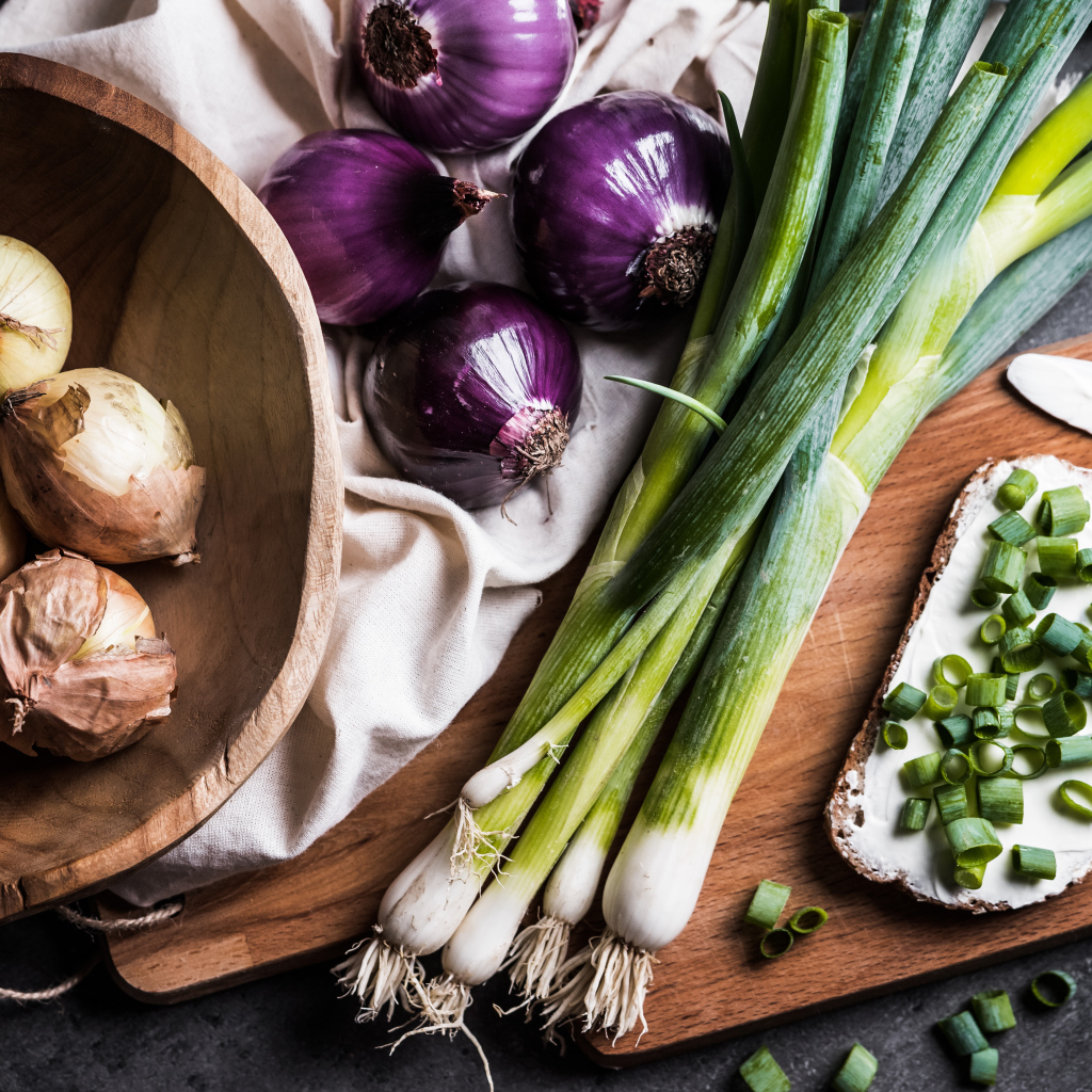 Бутерброд на столе с зеленым и репчатым луком