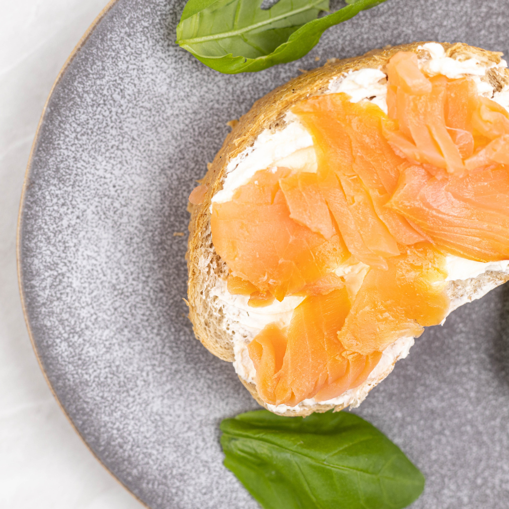 Бутерброд с сыром, красной рыбой и листьями базилика