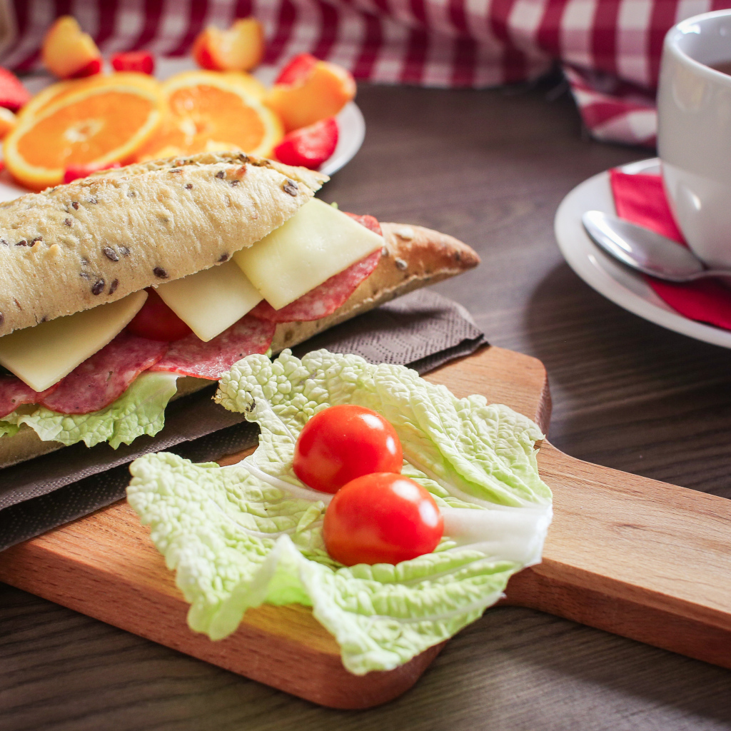 Бутерброды на столе с фруктами и чашкой чая