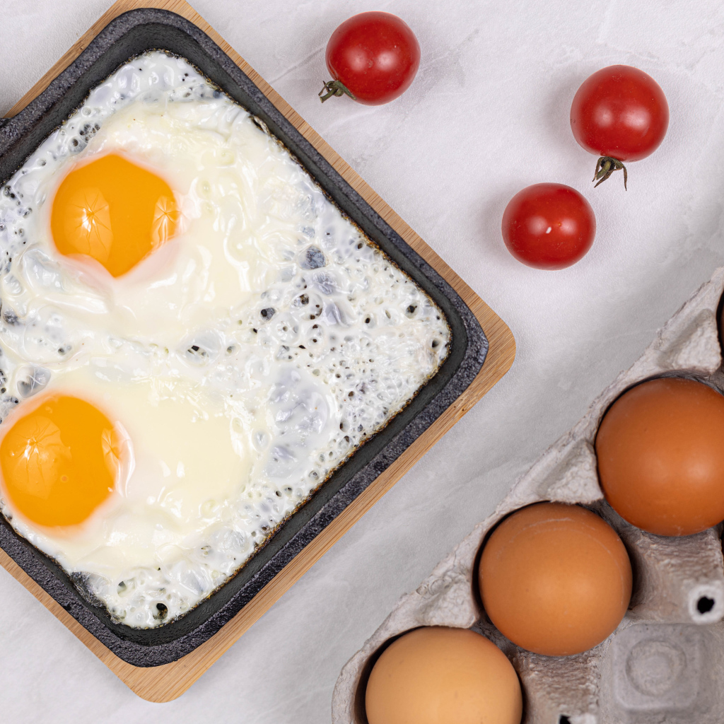 Яичница с помидорами и яйцами на столе