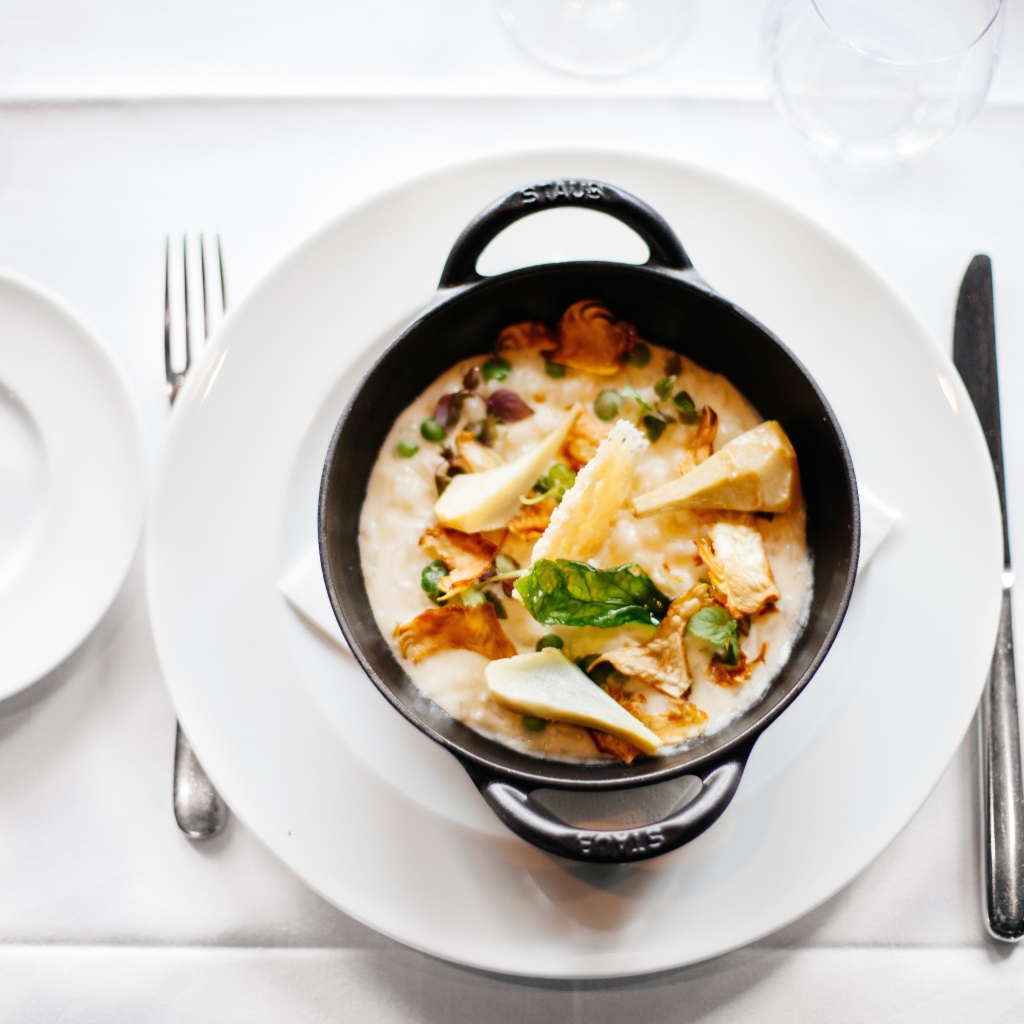 Суп в миске стоит на белой тарелке 