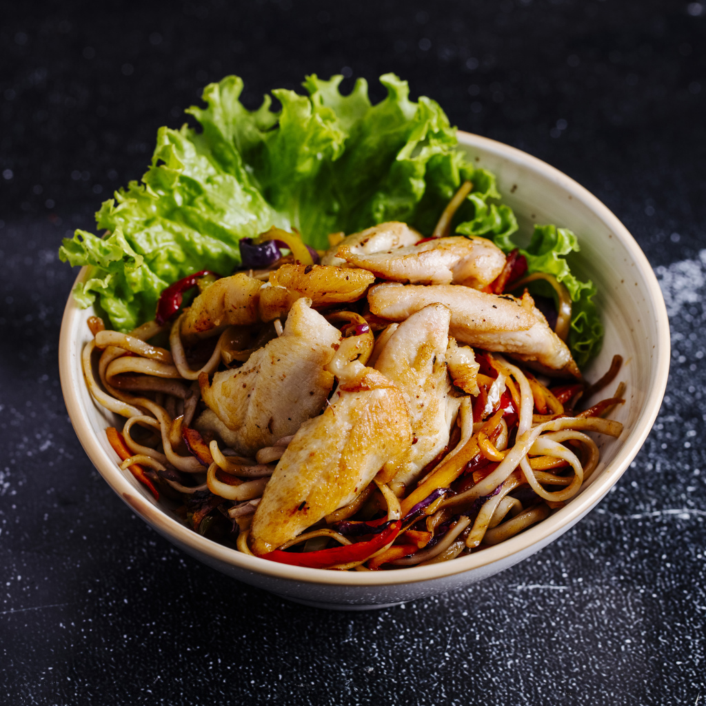 Спагетти в соусе с курицей и листьями салата 