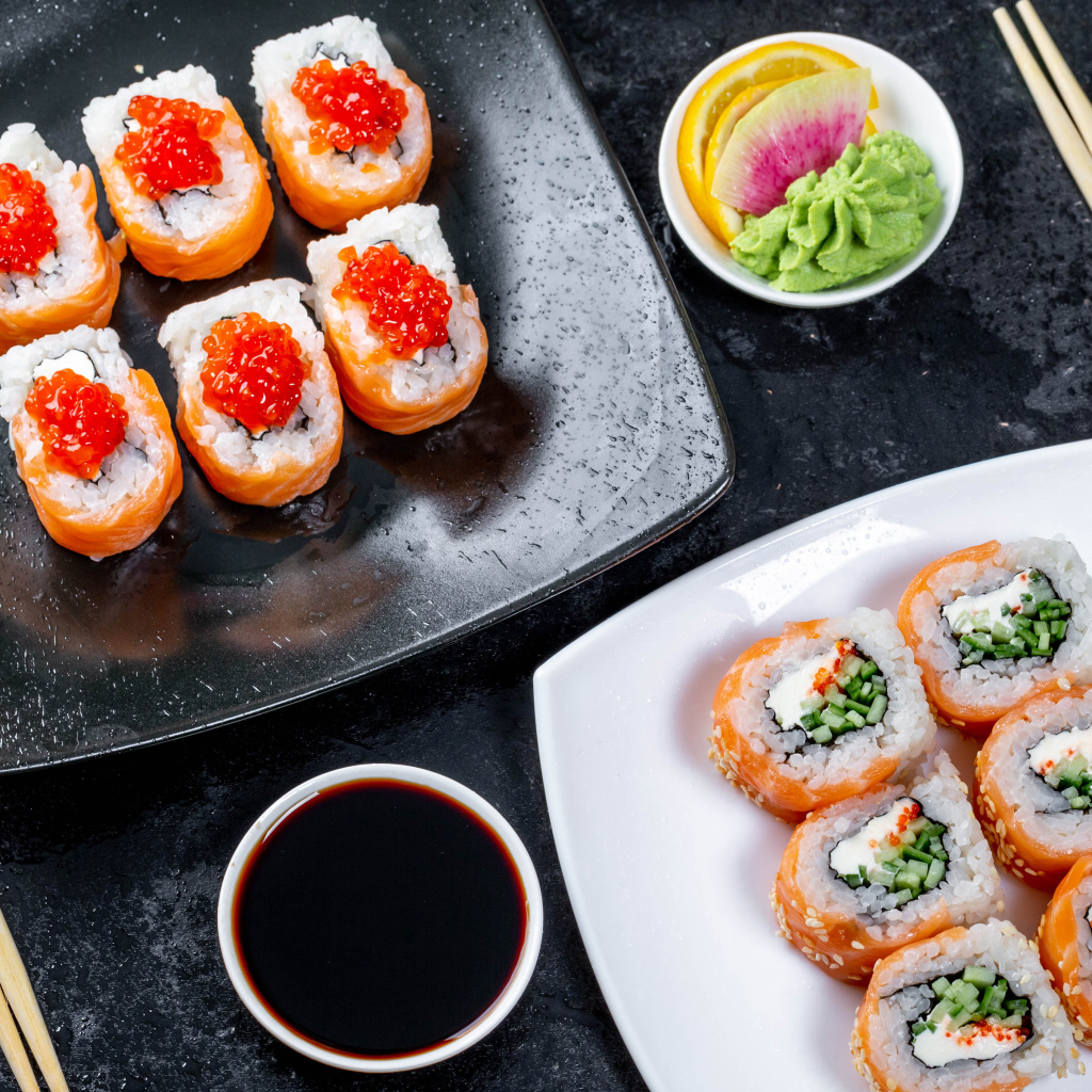 Sushi with red caviar and fish on a table with sauce and chopsticks