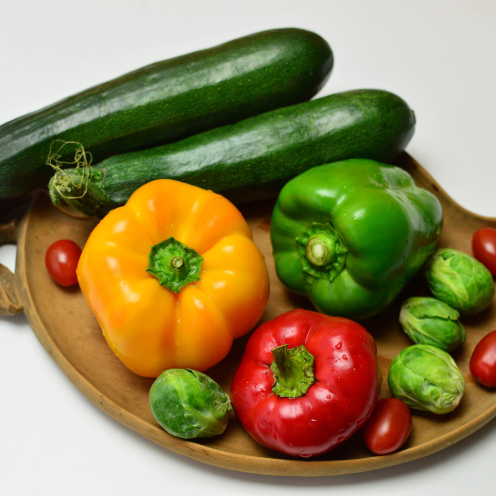 Сладкий перец, кабачки, помидоры и брюссельская капуста на сером фоне