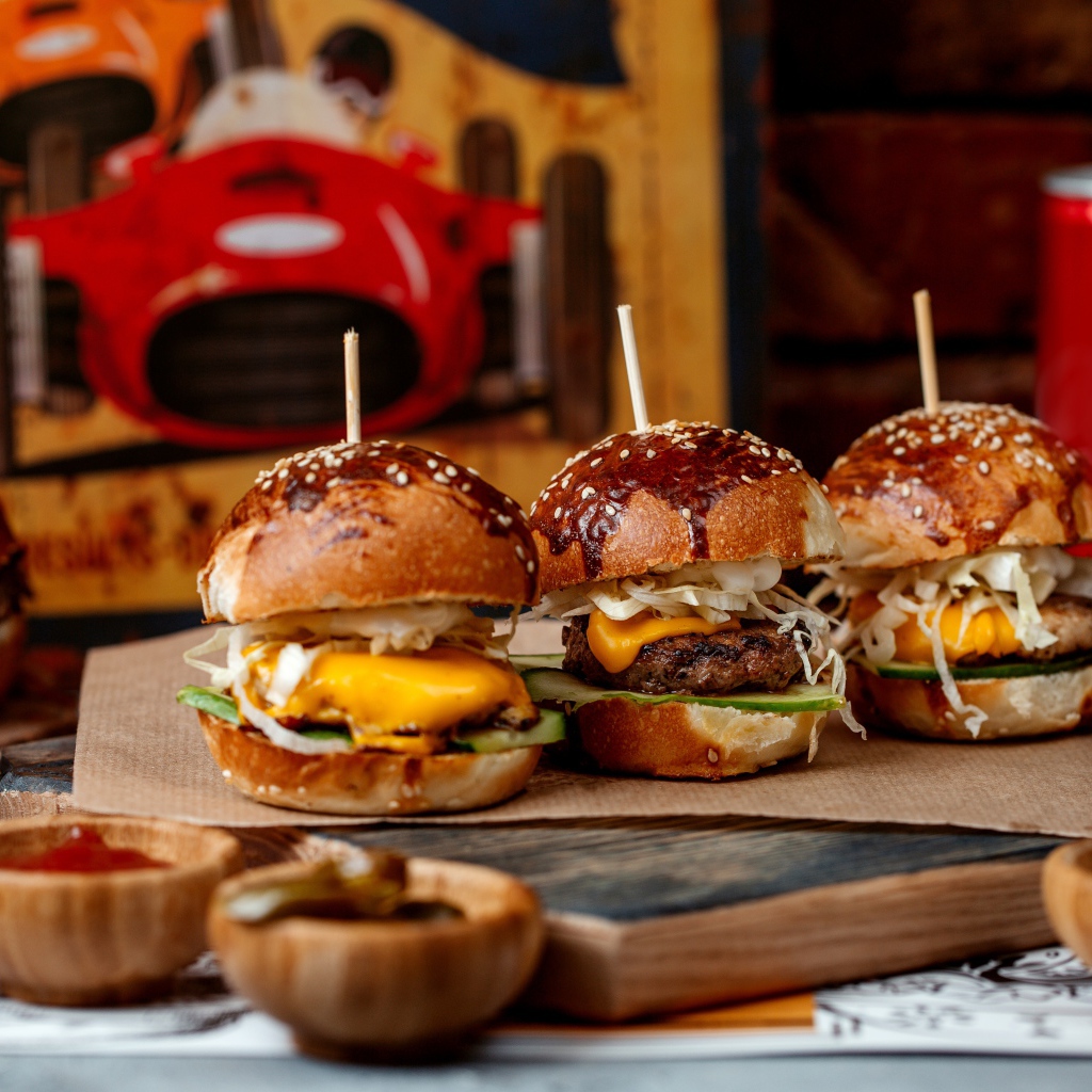 Вкусные гамбургеры на столе с соусом и кока колой 