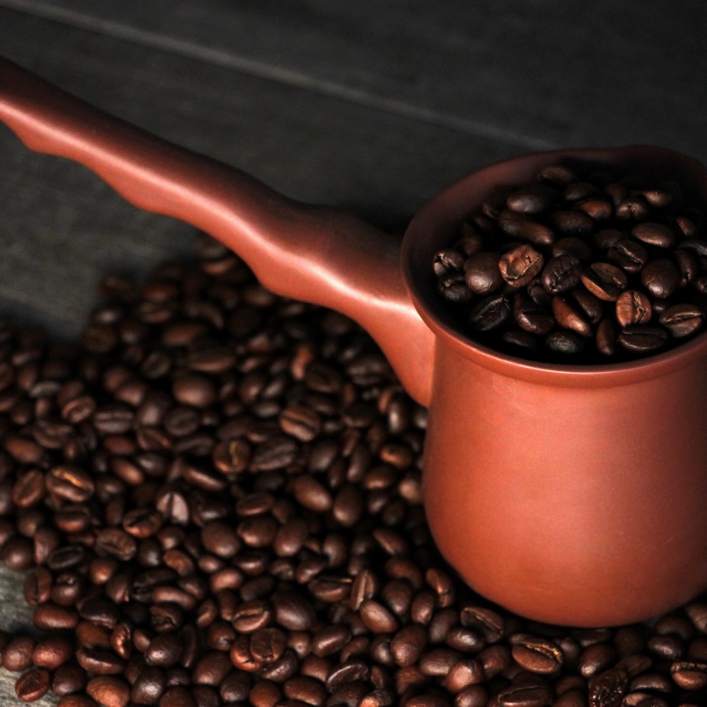 Турка с кофейными зернами на столе 