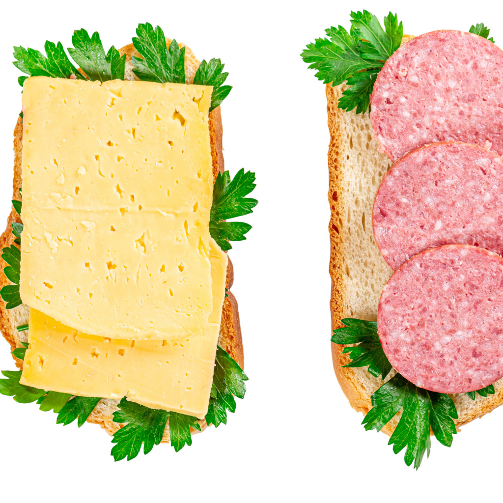 Два бутерброда с сыром,колбасой,петрушкой на белом фоне